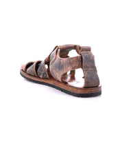 The Bed Stu Lone sandal features distressed brown leather straps and an antique brass buckle, offering a worn-in look. It's shown from the back at an angle against a white background.