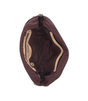 Interior view of an open, zippered Bed|Stü Lorien shoulder bag with a brown fabric lining, floral motif cutouts, and a small interior pocket.