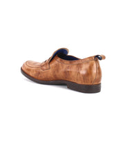 The Bed|Stü Lumaro brown men’s loafer, crafted from distressed leather, is shown from the back left side against a white background and features a low black heel in a slip-on design.