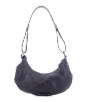 The Madre by Bed Stu is a black leather shoulder bag featuring a curved shape and adjustable strap, perfect for adding a statement-making touch to any outfit.