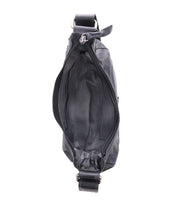 Top view of an open Madre by Bed Stu, a black leather crossbody bag that makes a statement with its edgy shoulder strap. It features a visible zipper and reveals its empty interior.
