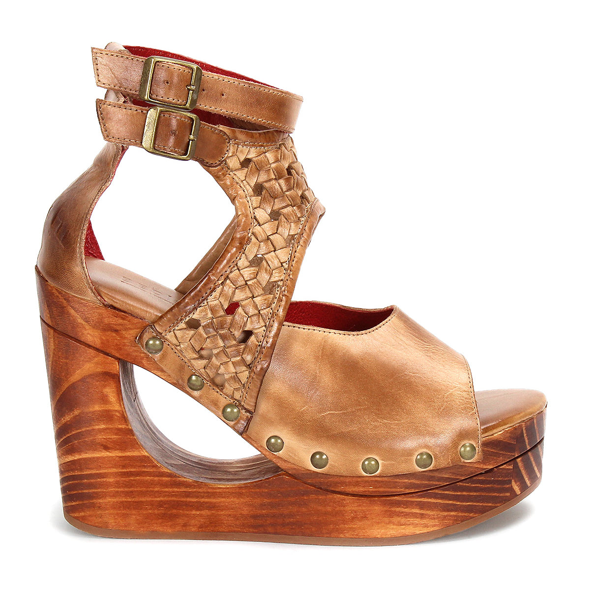 The Bed Stu Magic is a brown leather platform wedge sandal with a woven upper, adjustable buckle ankle strap, open toe, wooden base, and metal rivet accents.