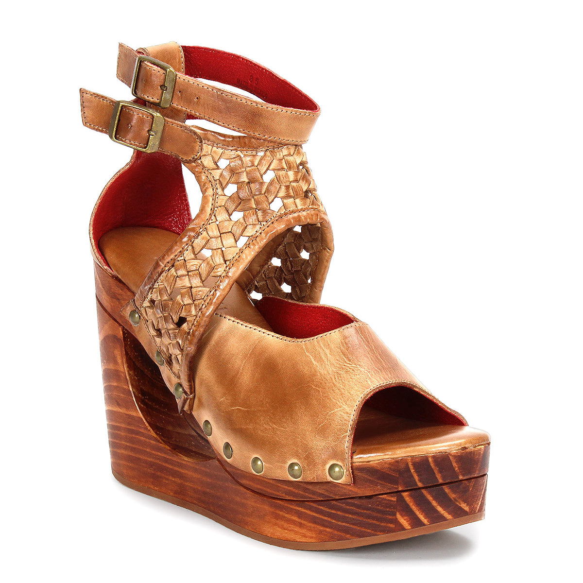 The Bed Stu Magic is a tan leather peep-toe wedge sandal featuring a woven upper, double buckled ankle straps, stud accents, and a chic platform wooden wedge heel.