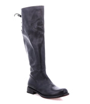 The Bed Stu Manchester is a black leather tall boot for women, featuring a low heel and lace-up detail at the back—perfect for timeless style and everyday versatility.