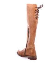 The Bed Stu Manchester boot, a women's knee-high essential in tan leather, features a side zipper and brown back laces, shown on a white background.