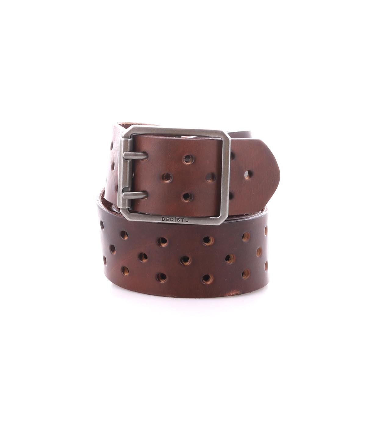 The Bed Stu Mccoy is a vegetable-tanned leather belt with multiple rows of holes and a silver rectangular buckle, blending classic style with modern appeal. Shown coiled on a white background.