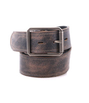 The Bed Stu Meander is a brown distressed leather belt with an antique metal buckle, shown rolled up on a white background.