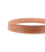 The Bed Stu Meander belt, featuring distressed brown leather and an antique metal buckle, is displayed in a circular shape on a white background.