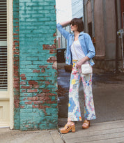 A woman finding comfort while standing next to a Bed Stu brick wall.