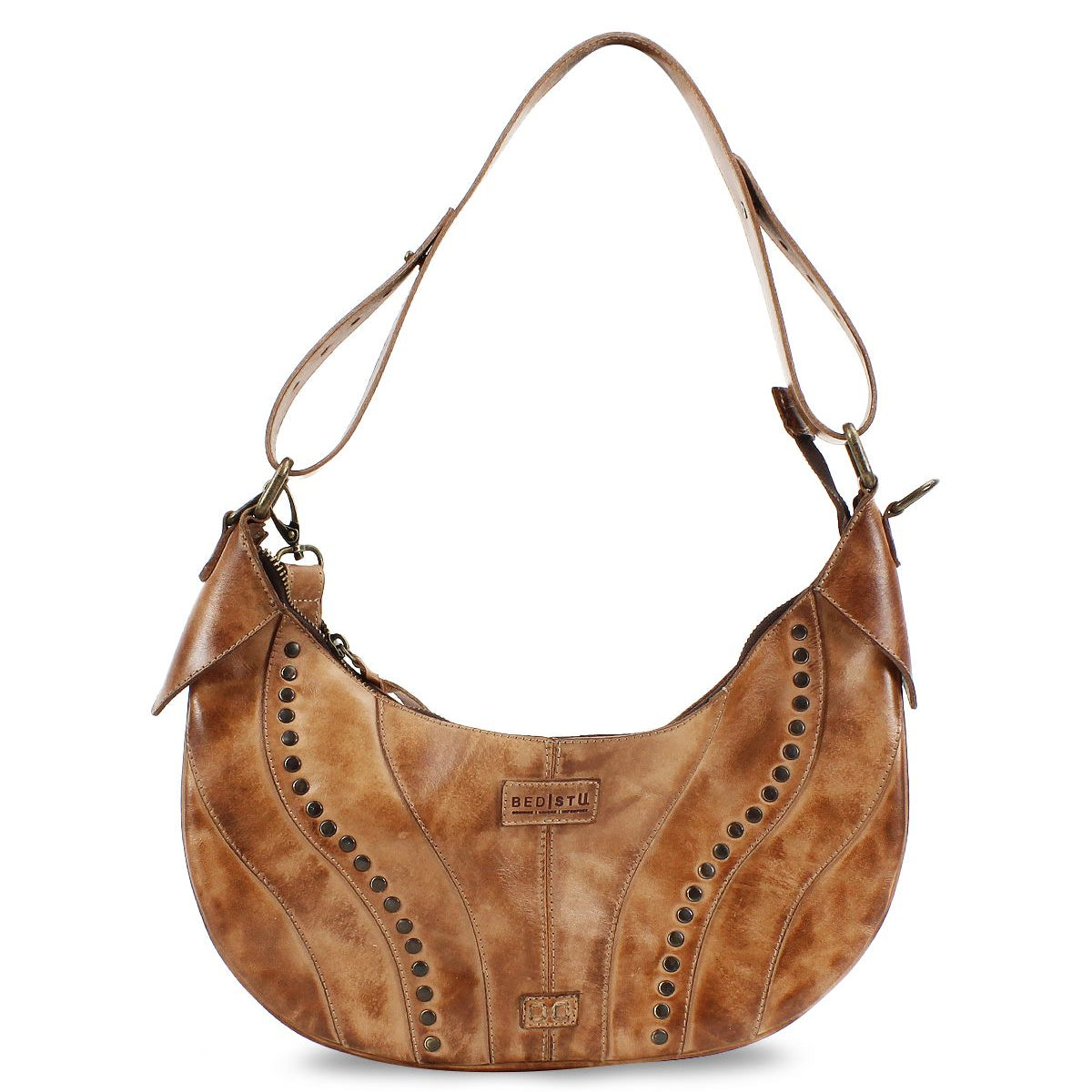 The Megara by Bed Stu is a brown leather saddle bag featuring decorative stitching and metal studs. It comes with an adjustable strap, leather details, and proudly displays the brand logo on the front.