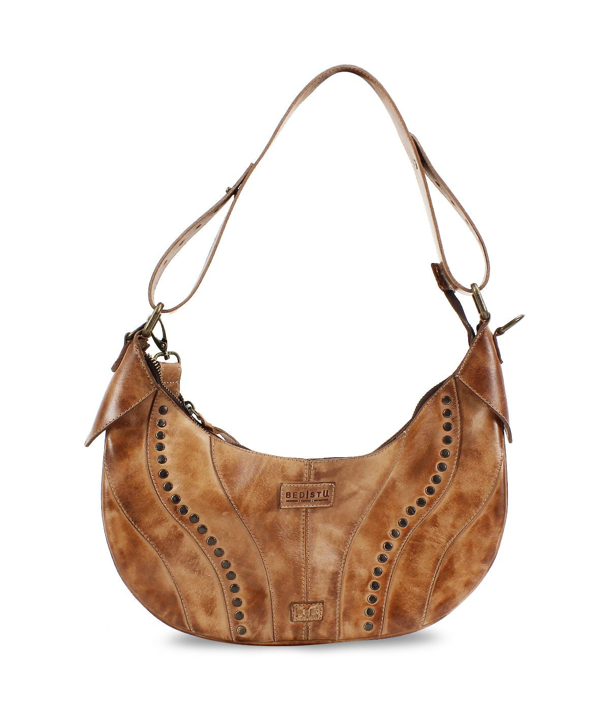 The Megara by Bed Stu is a brown leather saddle bag featuring decorative stitching and metal studs. It comes with an adjustable strap, leather details, and proudly displays the brand logo on the front.