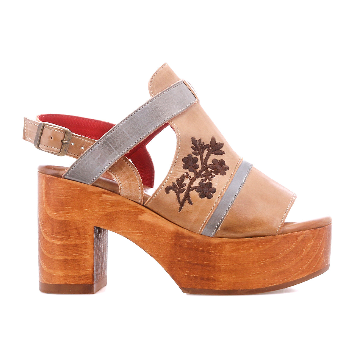 The Melodramatic by Bed Stu is a tan platform sandal with a chunky leather heel, gray straps, embroidered leather floral upper, and red cushioned lining.