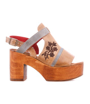 The Melodramatic by Bed Stu is a tan platform sandal with a chunky leather heel, gray straps, embroidered leather floral upper, and red cushioned lining.