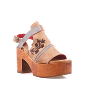 The Bed Stu "Melodramatic" is a tan and gray platform sandal with a chunky leather heel, embroidered floral side detail, open toe, and ankle strap.