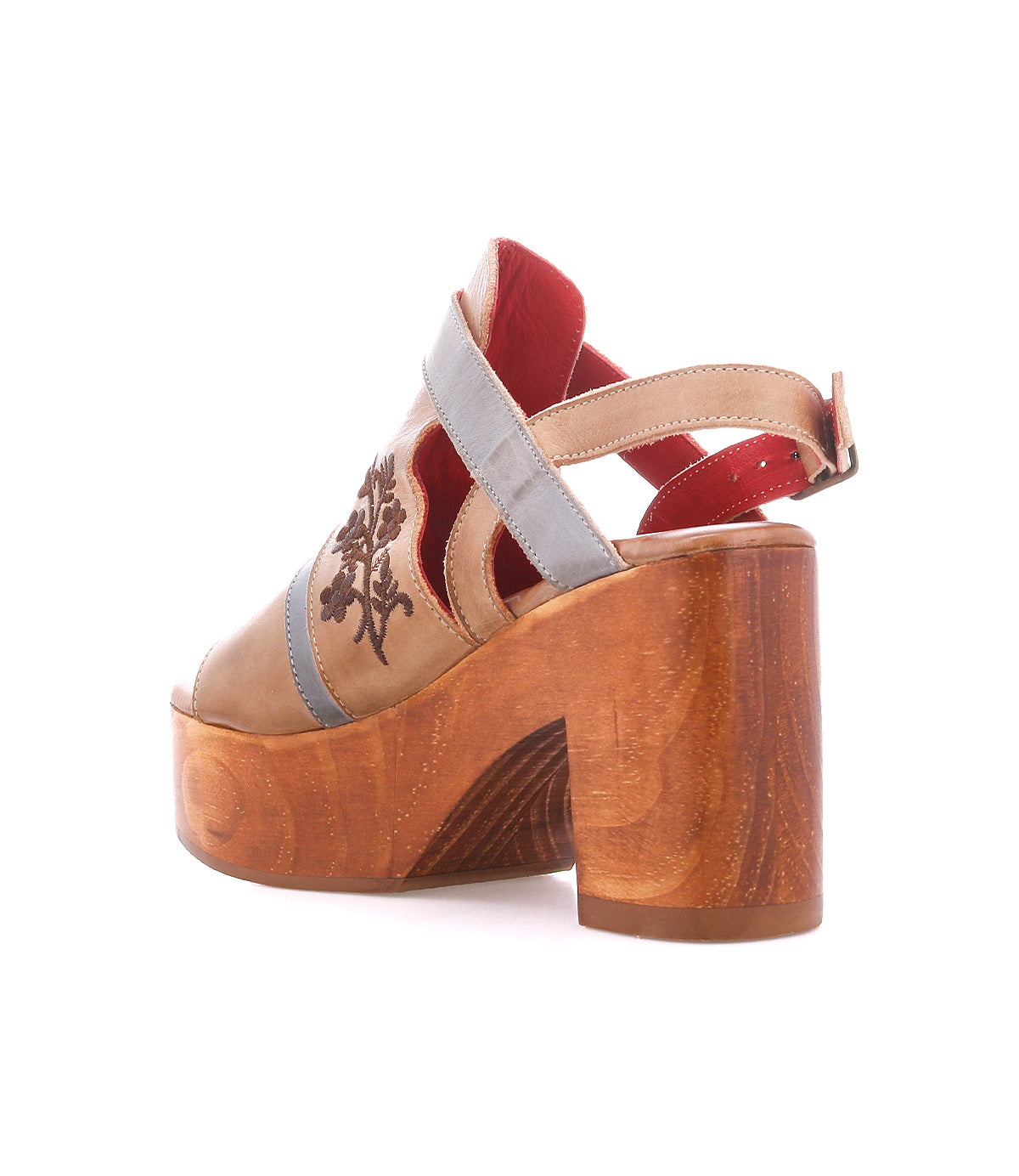 The Bed Stu Melodramatic is a high-heeled platform sandal featuring a chunky leather heel, wooden sole, tan leather upper, blue strap, red interior, and decorative side stitching.