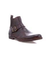 The Bed Stu Michelangelo is a brown leather ankle boot featuring a buckle accent, low heel, rounded toe, and durable rubber outsole, displayed on a white background.