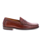 A single brown Bed Stu Moat penny loafer, handcrafted in Italy with high-quality leather, featuring a slight heel and viewed from the side.