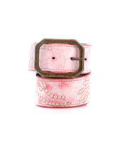 The Mohawk by Bed Stu is a women's pink leather belt with a vintage brass buckle featuring embossed floral and dotted patterns. Its design perfectly complements embroidered details for an elegant touch, and it coils neatly.