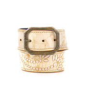 The Mohawk by Bed Stu is a beige belt featuring a floral design with embroidered details and a square brass buckle.