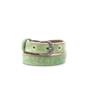 The Bed Stu Monae is a light green skinny leather belt with a silver buckle, neatly coiled on a white background—an ideal accessory for your boho style.