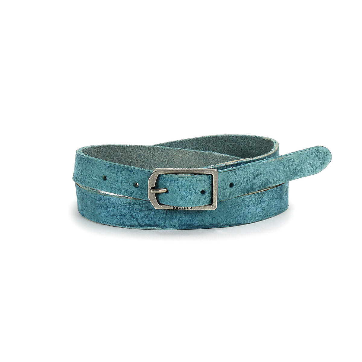 The Monae by Bed Stu, a teal suede skinny belt with a rectangular silver buckle, is coiled on a white background—ideal for bringing a boho touch to any outfit.