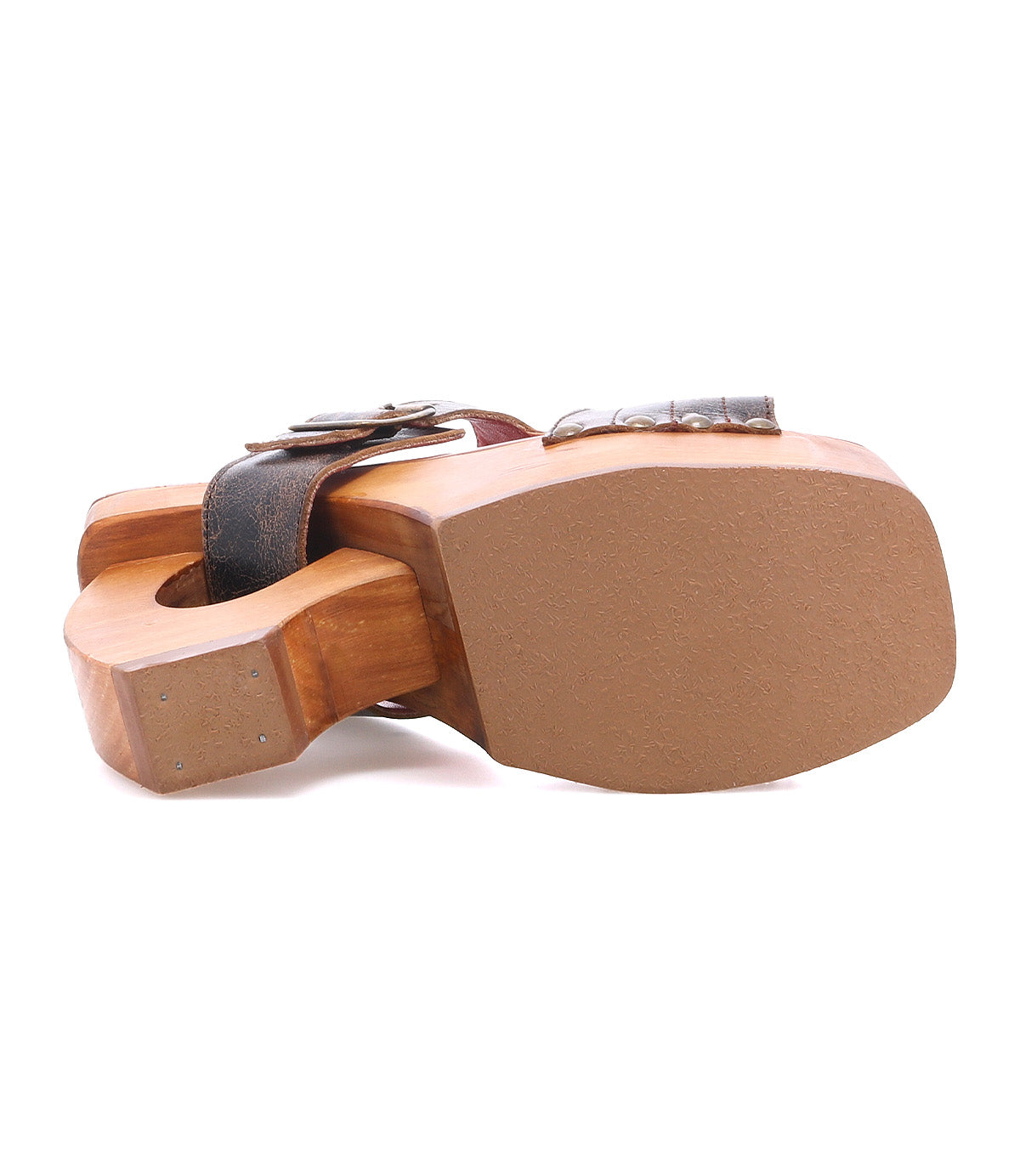 The Bed Stu Mutable is a wooden sandal lying on its side, featuring a decorative buckle and cutout heel design that showcases its vintage influence and wooden platform heel.
