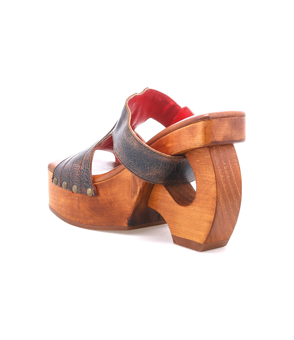 The Bed Stu Mutable is a vintage-inspired wooden platform sandal with an open heel, leather upper, decorative buckle, metal rivets, and red lining, shown solo on a white background.
