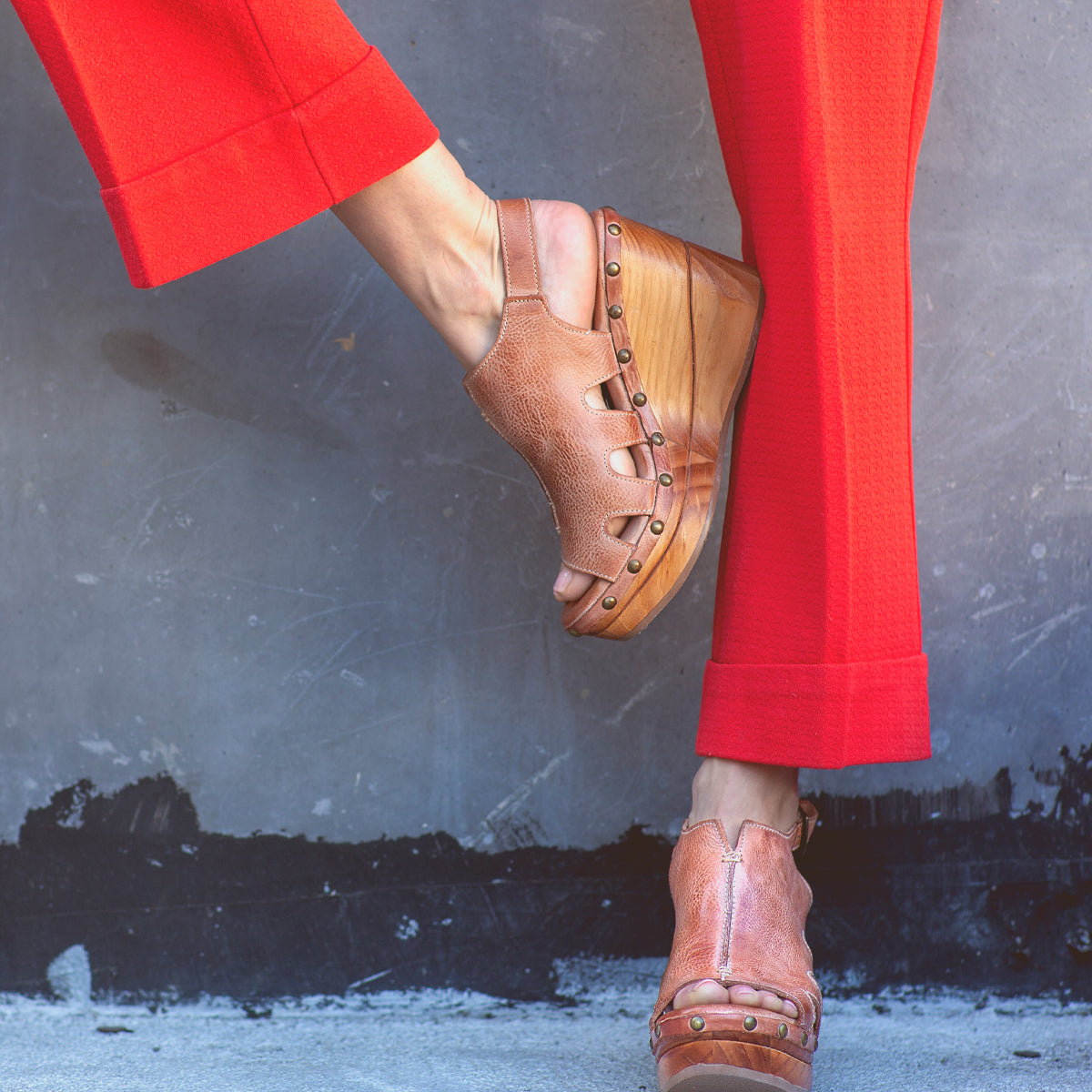A woman wearing red pants and a pair of Naiya by Bed Stu, showcasing her eco-friendly fashion sense.