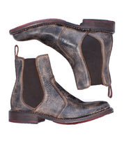 Two distressed brown leather Bed|Stü Nandi Chelsea boots with elastic side panels and red outsoles, a versatile footwear choice.