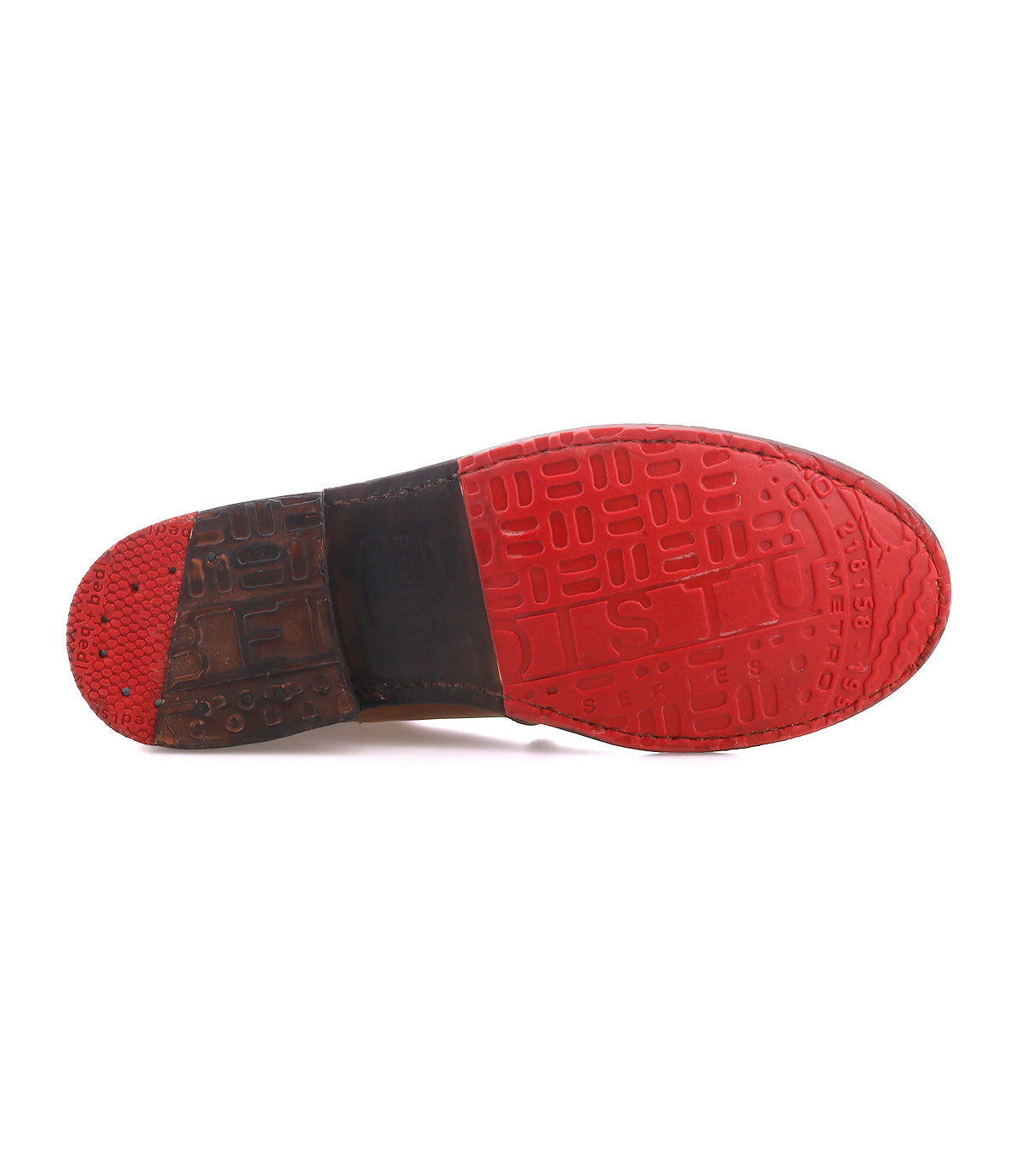 The image shows the underside of the Nandi by Bed|Stü, featuring a red rubber sole and brown heel section, highlighting its versatile footwear design.