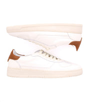 A pair of classic white sneakers, crafted from high-quality leather, featuring beige soles and light brown heel accents, displayed against a white background. The Bed Stu North is ideal for men's footwear collections.