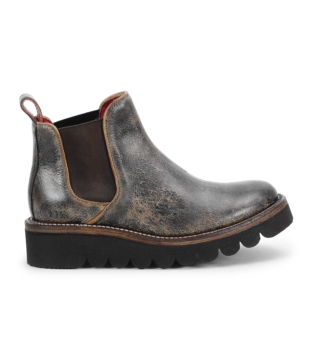 The Bed Stu Novel II is a worn-in leather Chelsea boot featuring elastic side panels, a pull tab, rugged texture, round toe, and a thick black scalloped lightweight sole.