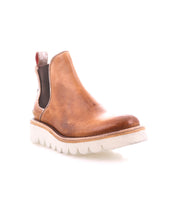 The Bed Stu Novel II is a brown leather Chelsea boot with a lightweight sole, black elastic side panels, and a red pull tab at the back, shown on a white background.