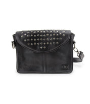 The Occurrence by Bed Stu is a versatile bag with an edgy design, boasting a black leather crossbody style. It features a studded flap and an adjustable strap.