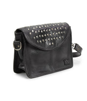 The Occurrence by Bed Stu is a black leather handbag adorned with silver studs on the flap and features a detachable shoulder strap, catering to those looking for an edgy design. This versatile bag effortlessly transforms into a chic crossbody suitable for any occasion.