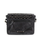 The Occurrence by Bed Stu is a black leather crossbody bag with an edgy design, featuring a front zipper pocket and metallic stud accents on the flap.