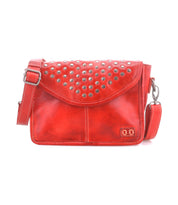 Bed Stu’s Occurrence crossbody is a compact red leather bag accented with silver studs on the flap and features an adjustable shoulder strap for effortless style.
