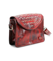 The Occurrence by Bed Stu is a red leather crossbody bag with a flap closure, highlighted by silver studs and a detachable strap.