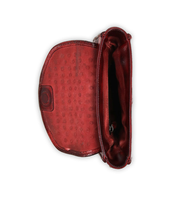 Top-down view of the Bed Stu Occurrence: an open red leather crossbody bag featuring a polka dot interior and button clasp.