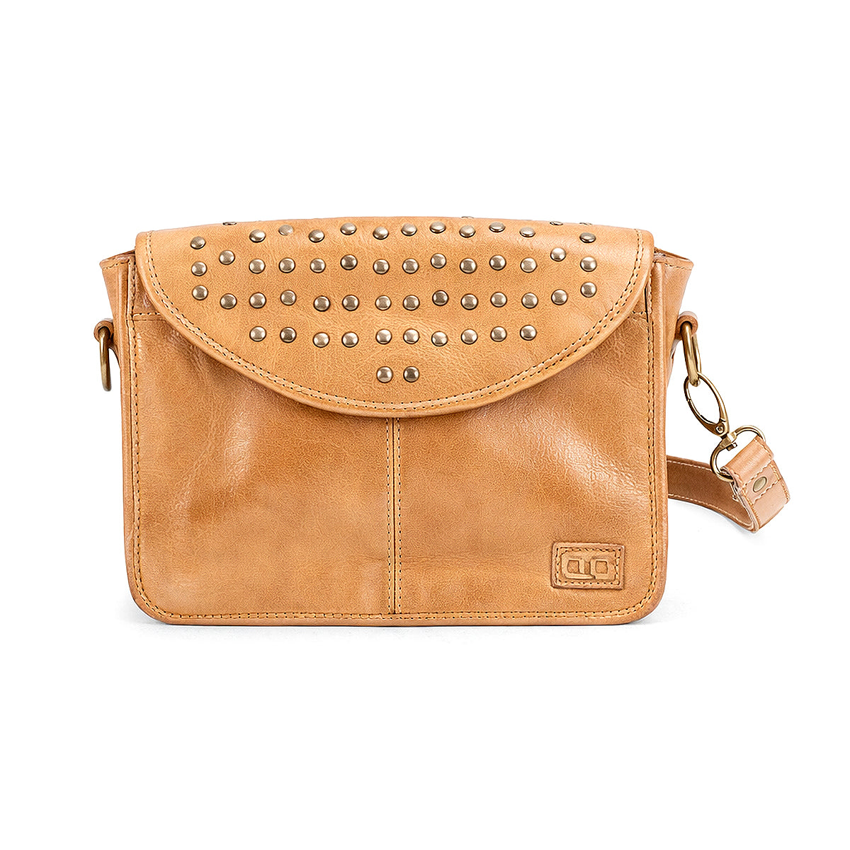 The Bed Stu Occurrence is a tan leather crossbody bag with flap closure, metal stud details, detachable strap, and a small rectangular logo patch on the front—stylish and versatile for any occasion.