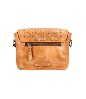 The Bed Stu Occurrence is a tan leather crossbody bag featuring silver studs on the flap, a front zipper pocket, and an embossed "BED|STU" logo—combining versatile style and function in one accessory.