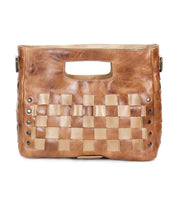 The Orchid by Bed Stu is a brown leather handwoven handbag with checkerboard panels, a cut-out handle, and metal stud accents on the sides.
