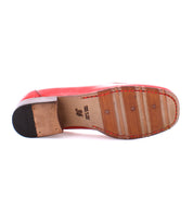 Bottom view of a red Bed Stu Paris penny loafer, showcasing a worn wooden sole with visible nails and a partially attached rubber heel. The size mark "36" and other text are printed on the sole, hinting at its classic style.