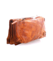 The Parle by Bed Stu is a brown leather toiletry bag with a versatile design, slightly worn appearance, and zipper closure, showcased against a plain white background.