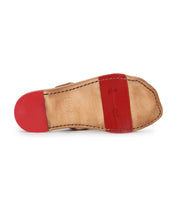 The image shows the underside of the Bed Stu Path shoe featuring a tan leather sole with red Vibram rubber plates on the heel and ball, visible stitching, stylish metal grommets, and stamped branding.