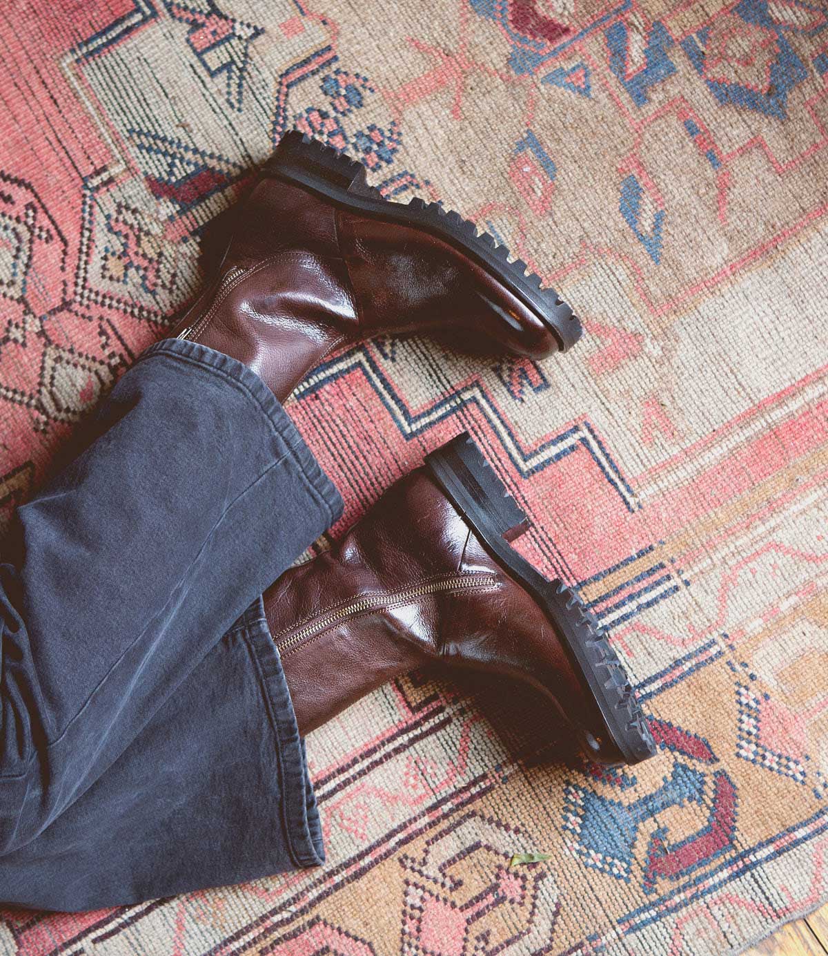 A person's convenience feet on a Bed Stu Ploy rug.