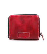 The Bed Stu Plus is a small, rectangular red leather wallet with a zipper closure and "BED STU" embossed on the front. It features a zippered coin pocket for extra convenience.