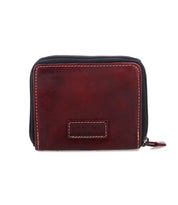 The Bed Stu Plus is a closed, rectangular bifold wallet in dark brown with visible stitching and a zippered coin pocket, shown against a plain white background.