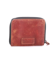 Bed|Stü Plus compact brown leather bifold wallet with a zip-around closure and a small embossed logo patch on the front.