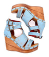 A pair of blue wedge sandals, the Princess sandals by Bed Stu, with sustainable wooden straps and woven strappy uppers.